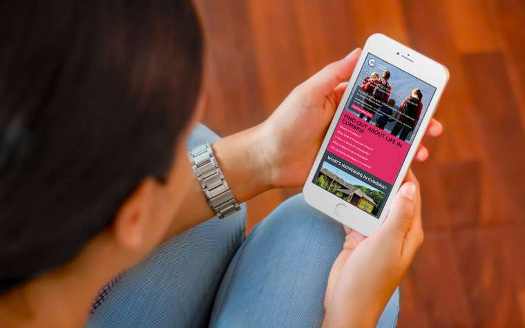 Woman viewing Choose Cumbria on mobile